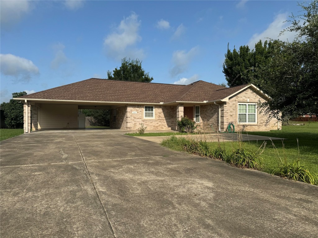 a front view of a house with a garden and lake view