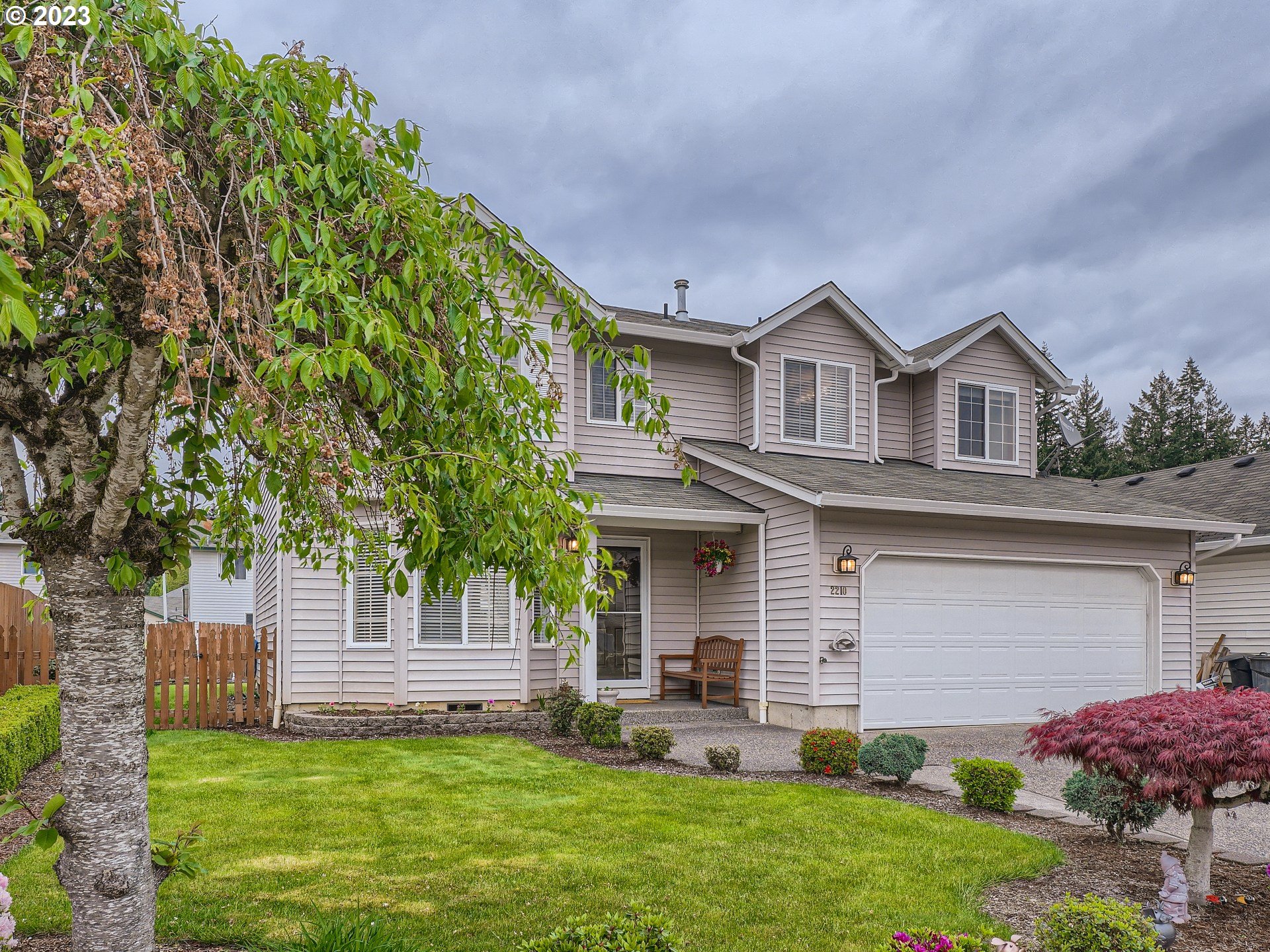 a front view of a house with a garden and yard