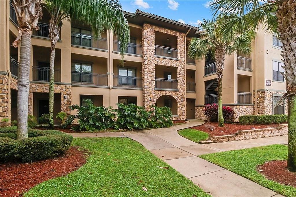 a front view of a multi story residential apartment building with a yard