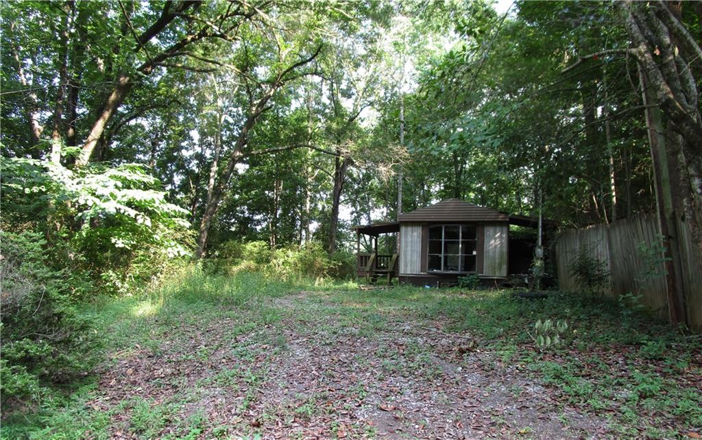 a view of a house with large trees and a small barn