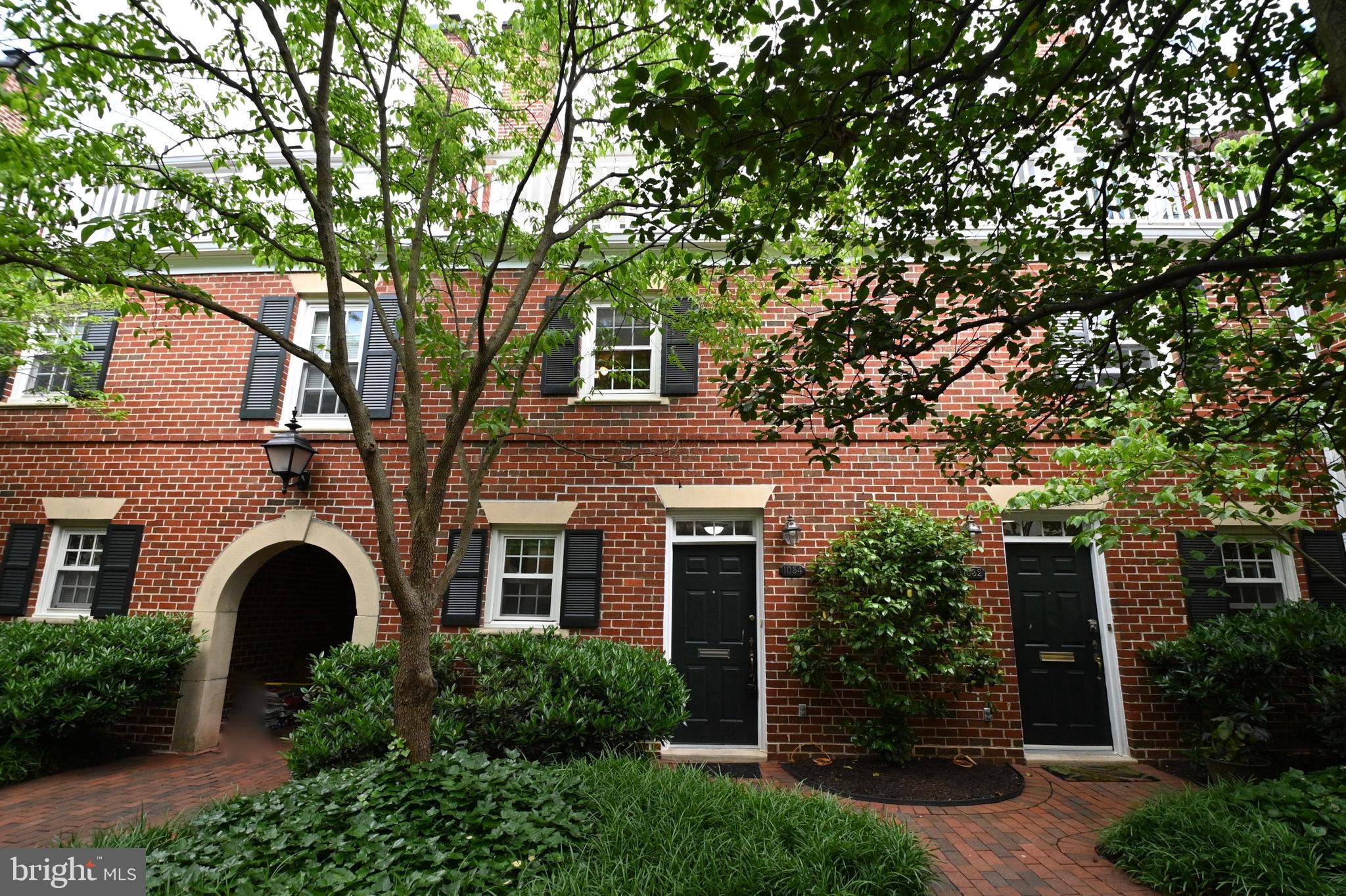 a front view of a house with plants and trees