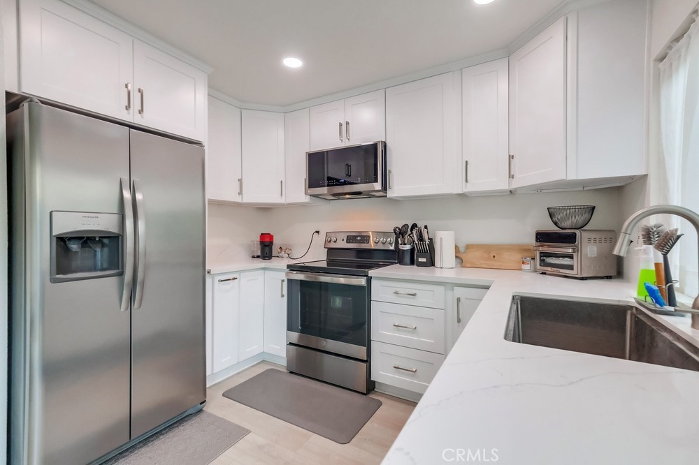 a kitchen with stainless steel appliances granite countertop a refrigerator sink and cabinets