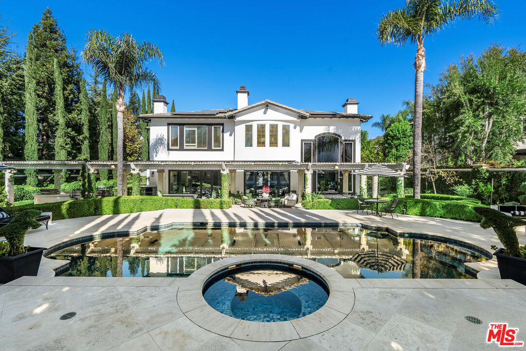 a view of a house with swimming pool and sitting area