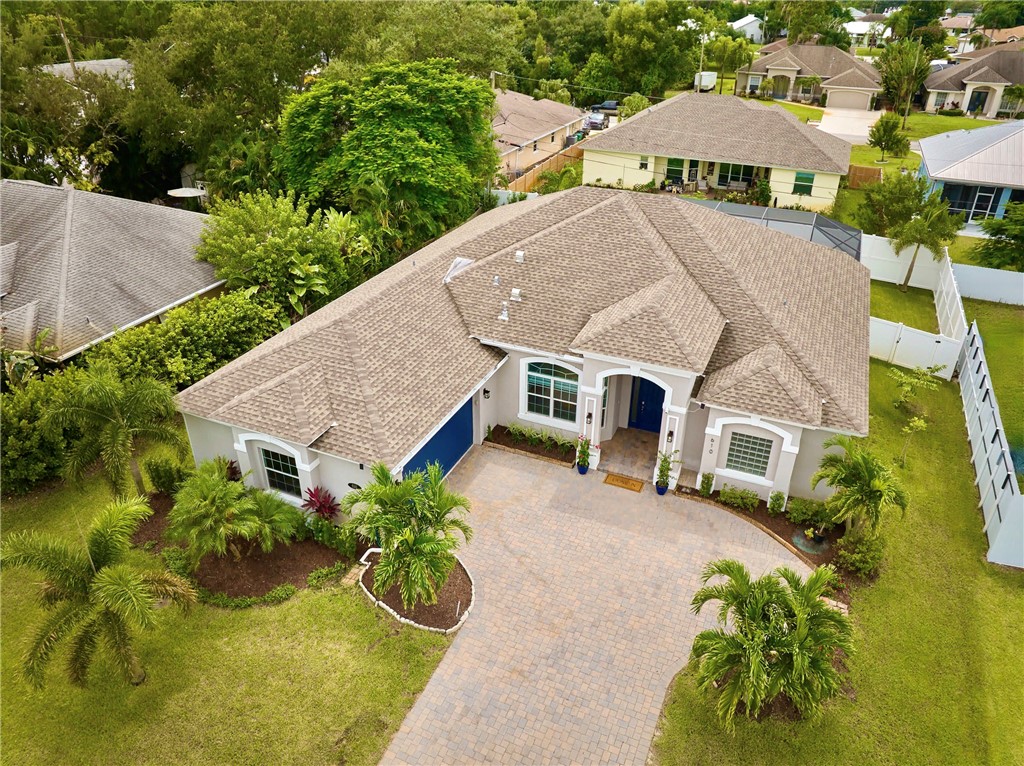 an aerial view of a house with yard and swimming pool