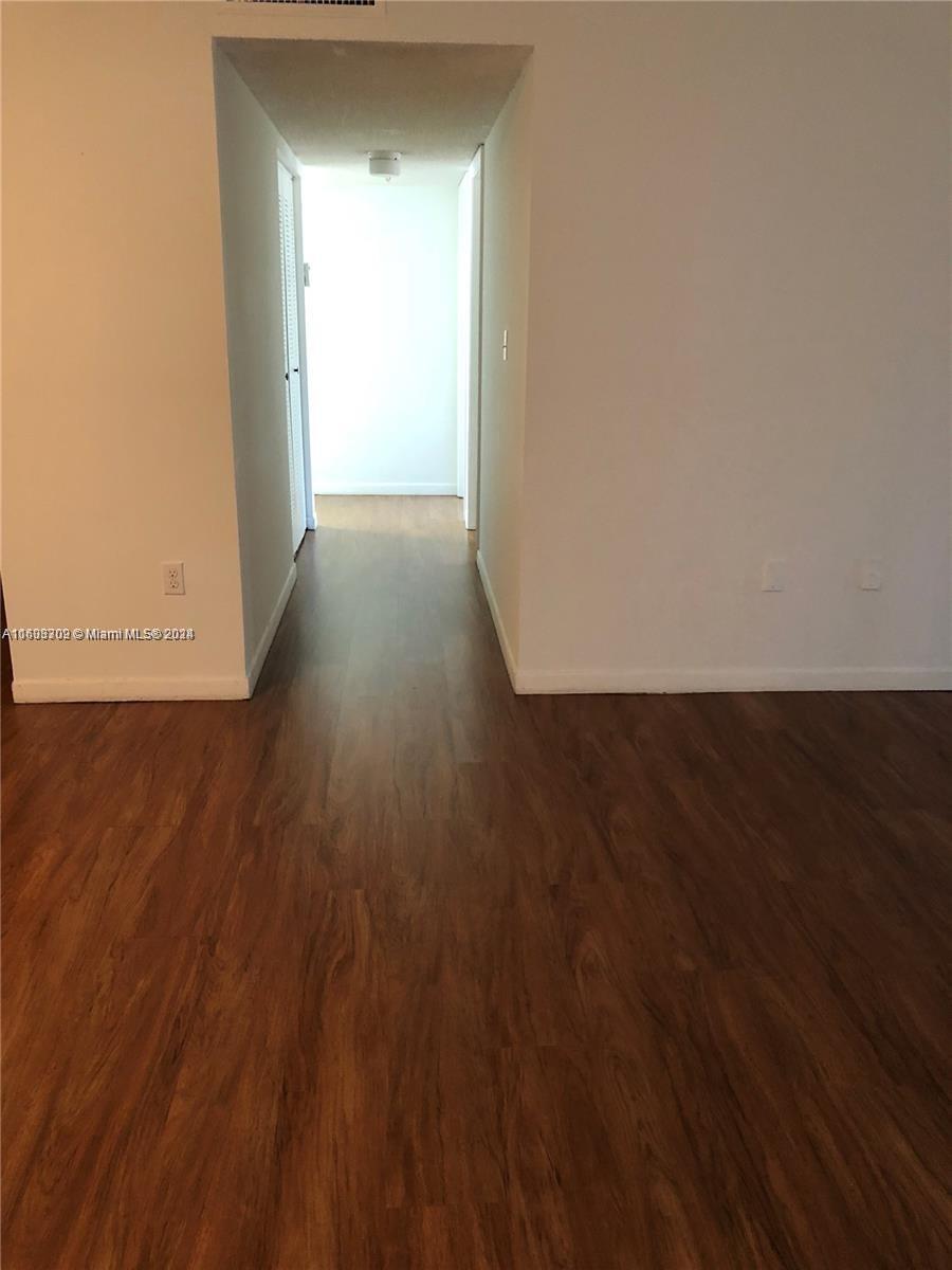 an empty room with wooden floor and closet