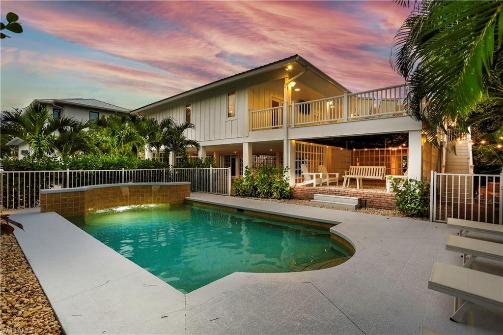 a view of a house with swimming pool and sitting area