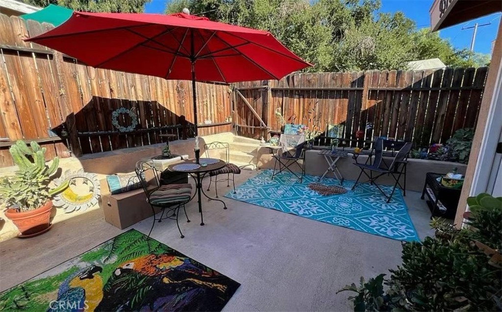 a view of a table and chairs under an umbrella in backyard