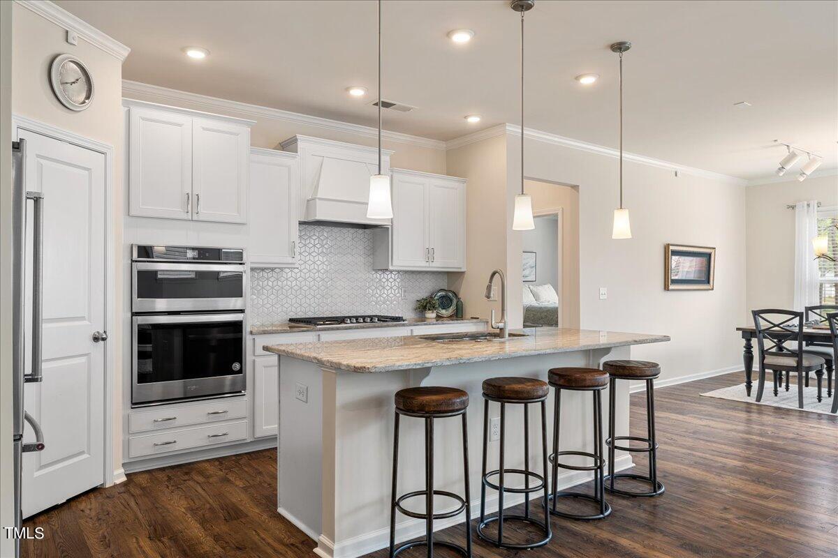 a kitchen with a stove a sink a dining table and chairs