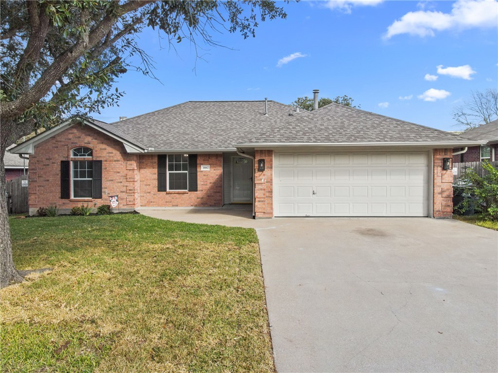 Ranch-style home with a garage and a front lawn