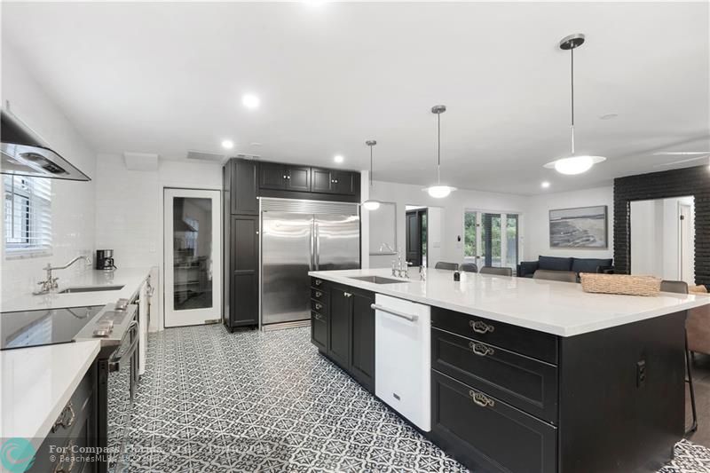 a kitchen with a sink a counter top space stainless steel appliances and cabinets