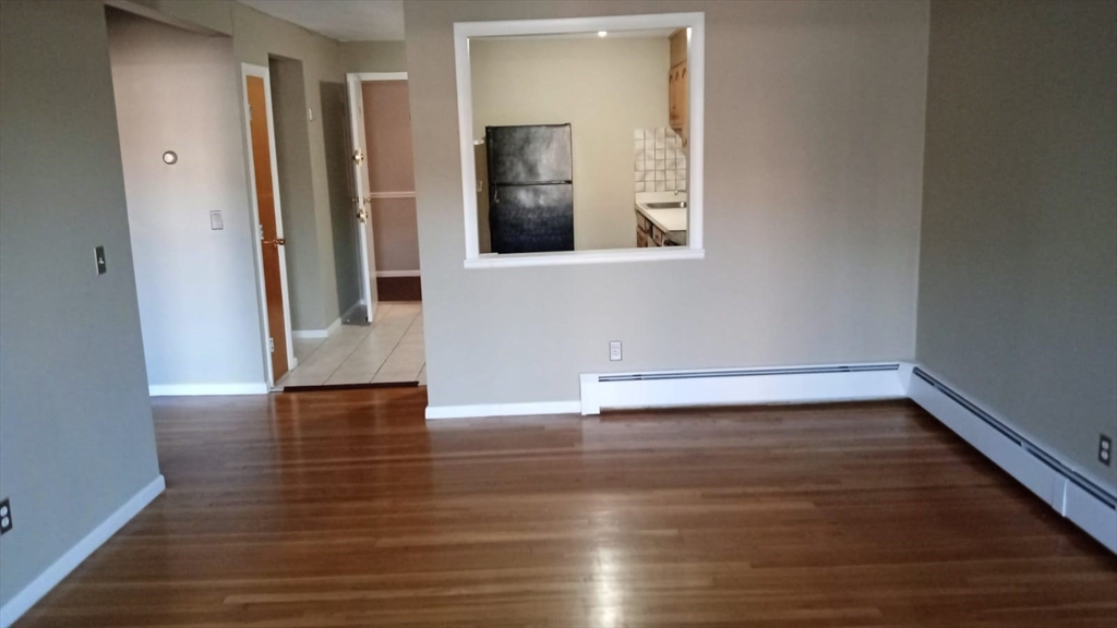 a view of a room with wooden floor and entryway