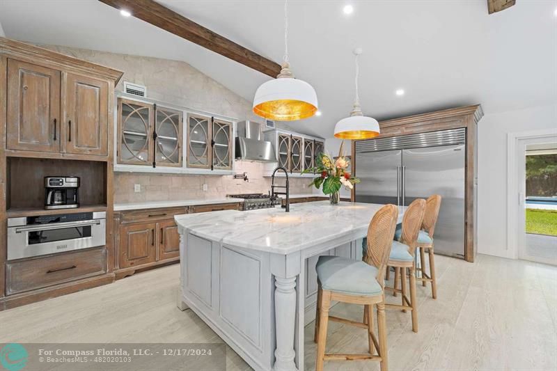 a kitchen with cabinets and chairs