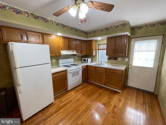 a kitchen with a refrigerator a sink and dishwasher with wooden floor