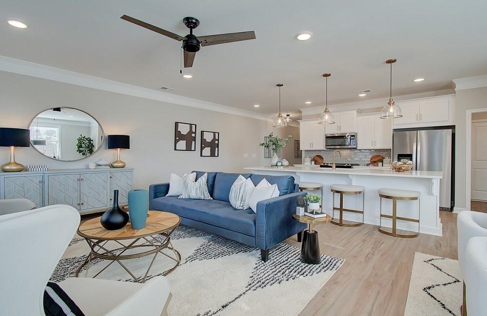 a living room with kitchen island furniture and a view of kitchen