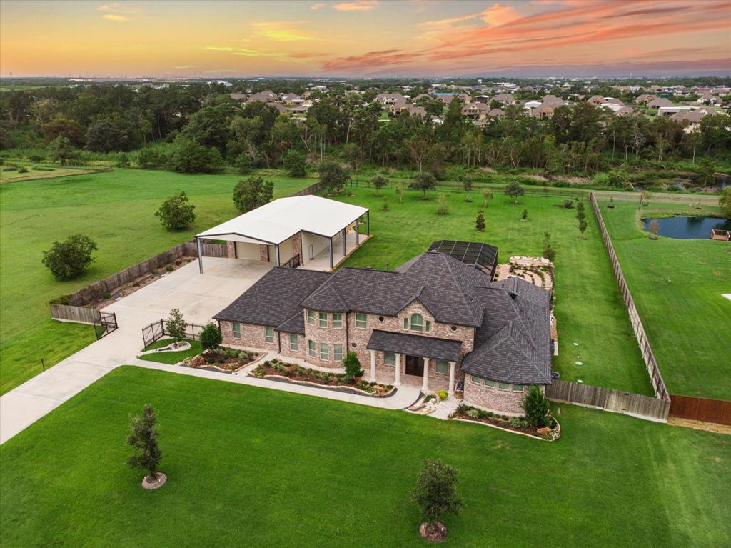 an aerial view of a house with swimming pool garden and trees