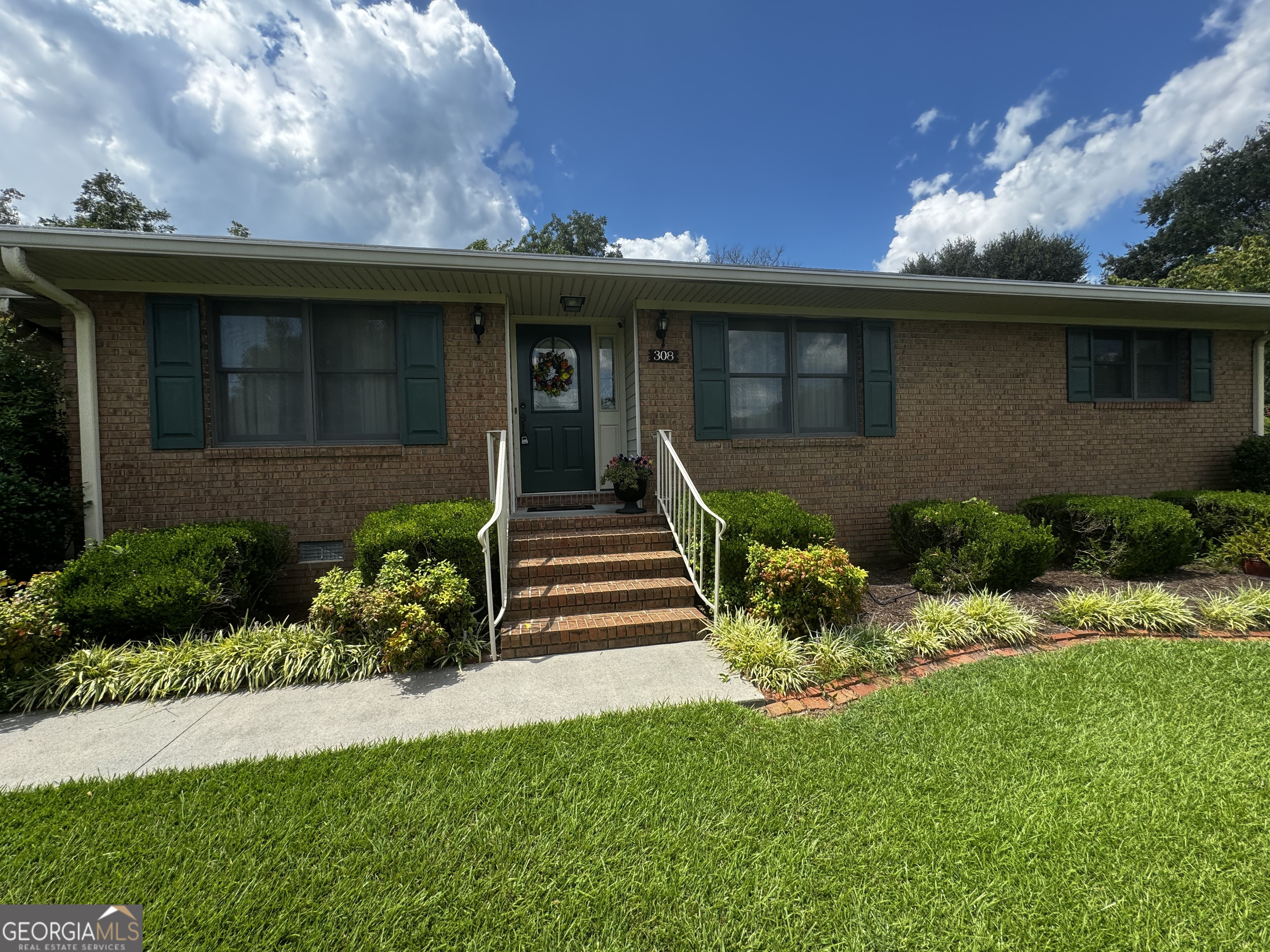 a front view of a house with a garden