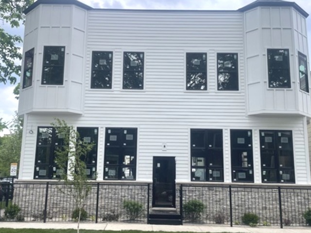 a view of a brick house with large windows