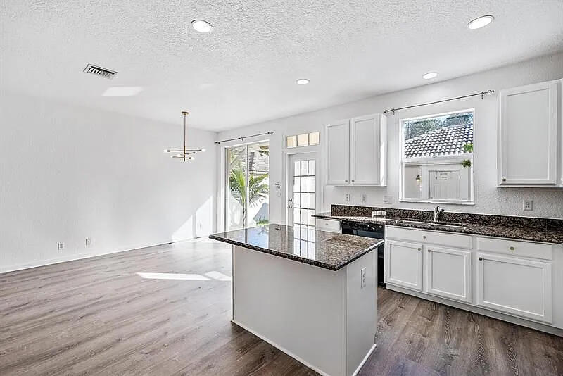 a kitchen with granite countertop white cabinets and white appliances