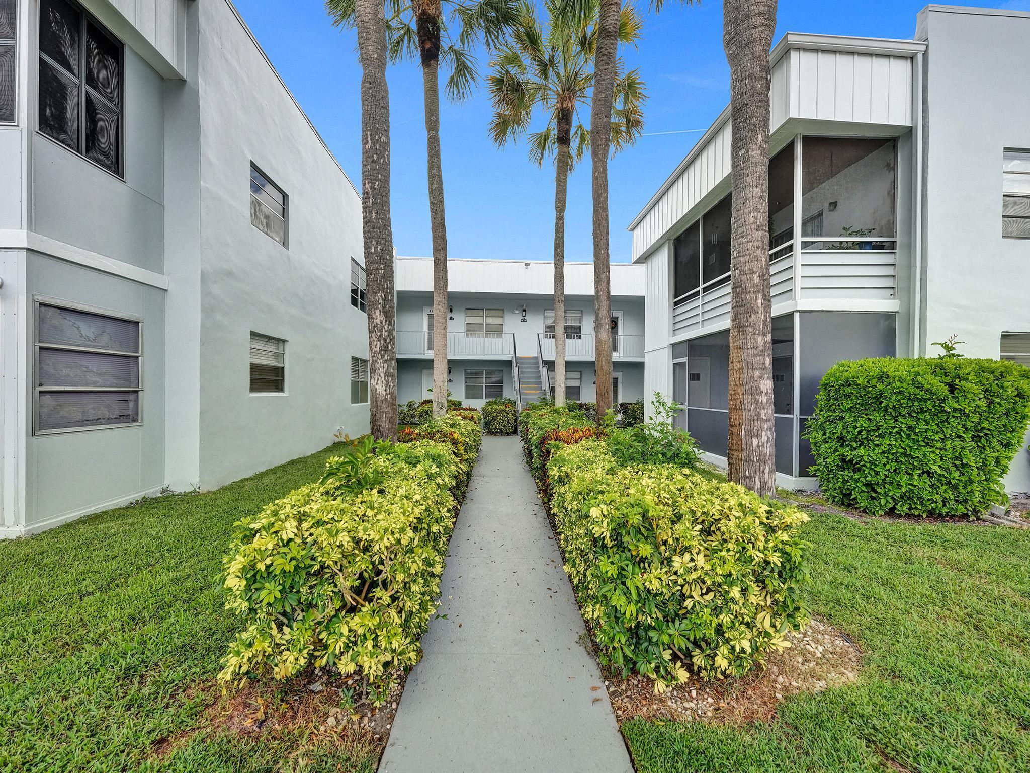 a view of a house with a yard and pathway