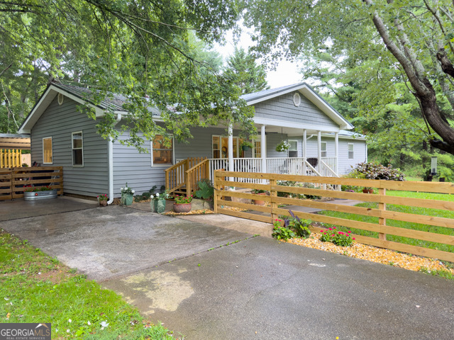 a view of a house with a yard and large tree