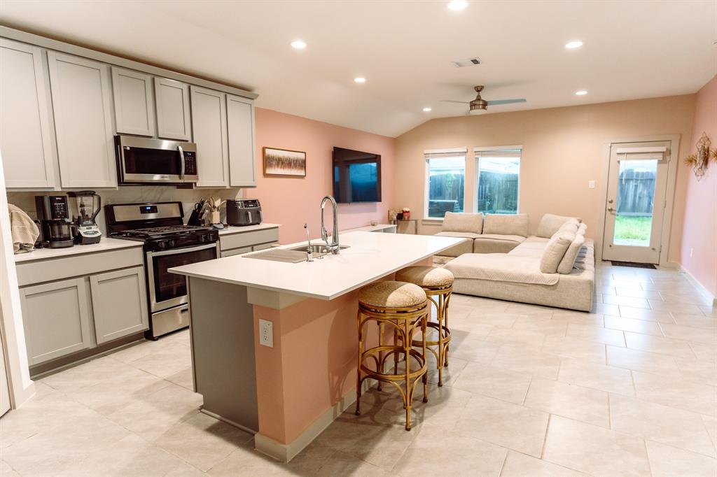 a kitchen with stainless steel appliances kitchen island granite countertop a sink and cabinets