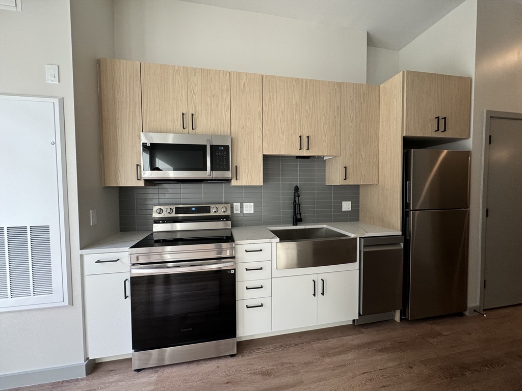 a kitchen with white cabinets and stainless steel appliances