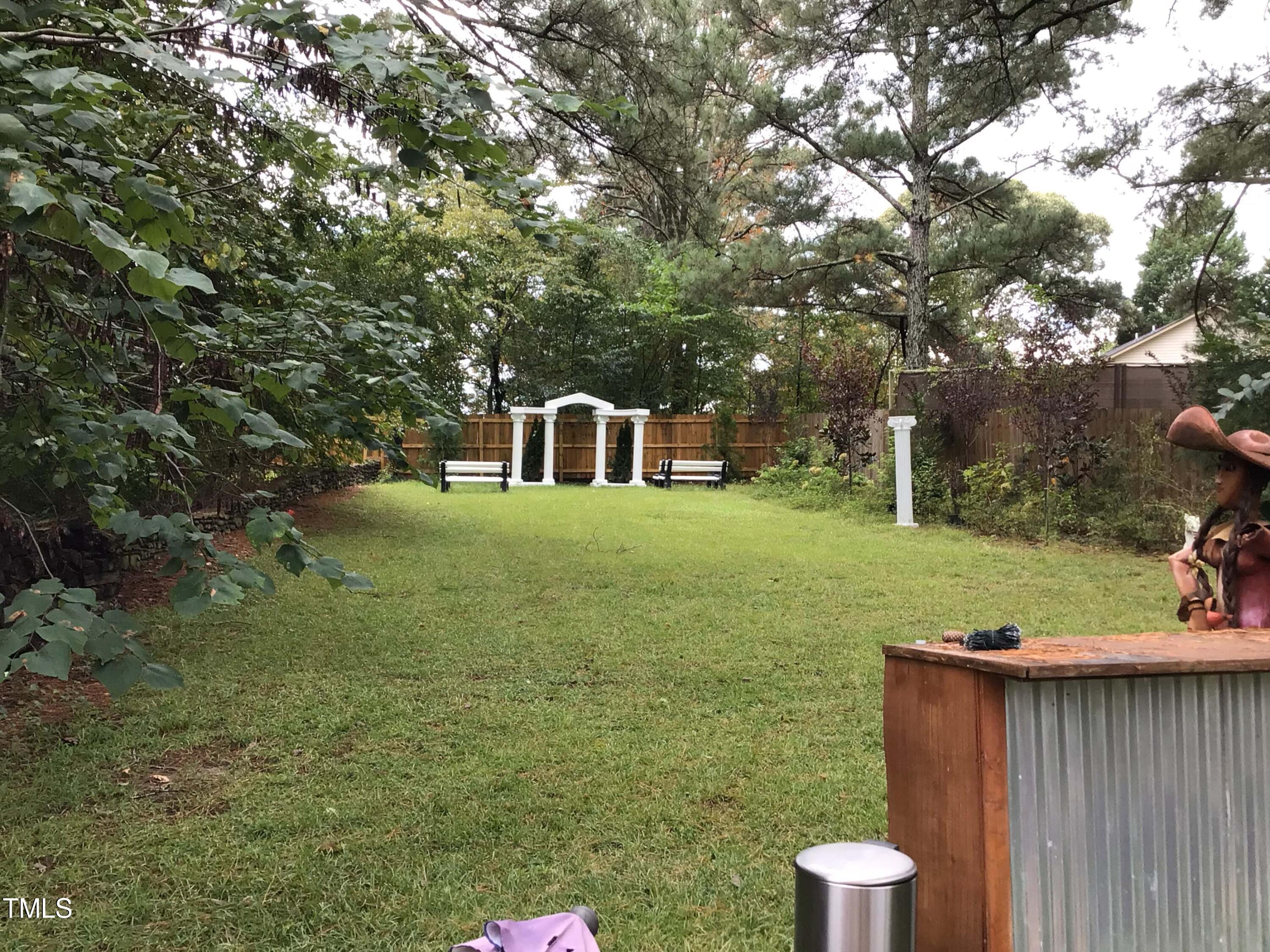 a view of a backyard with table and chairs and wooden fence