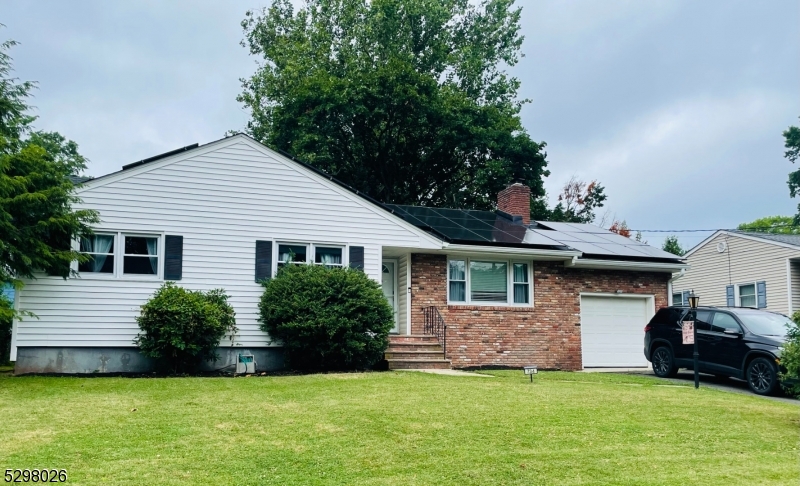 a front view of a house with a garden and trees