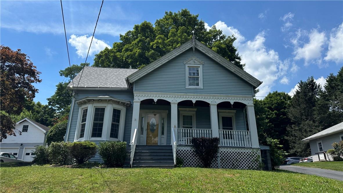 View of front of property with a porch and a front lawn