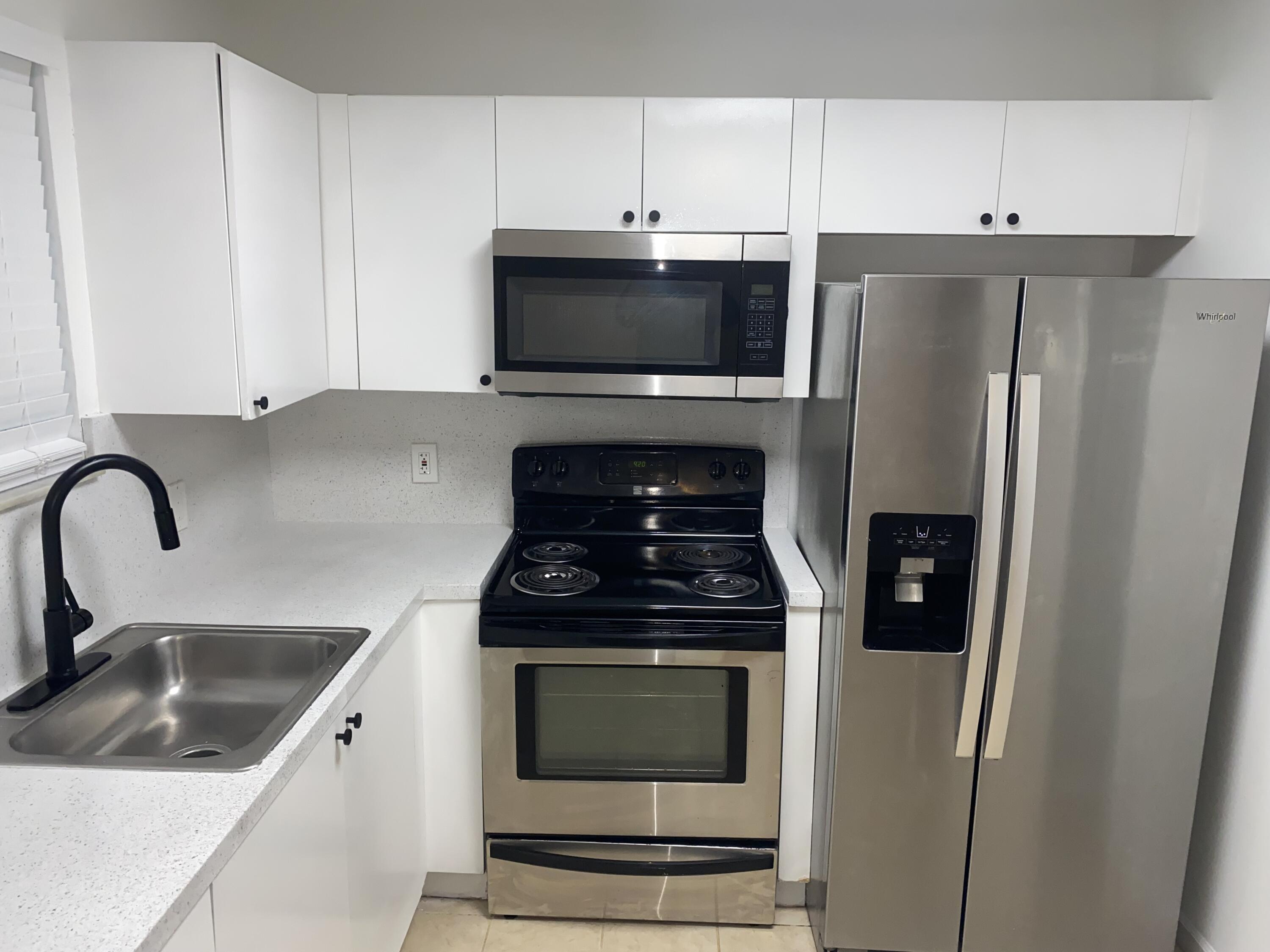 a kitchen with stainless steel appliances a stove a refrigerator and a sink