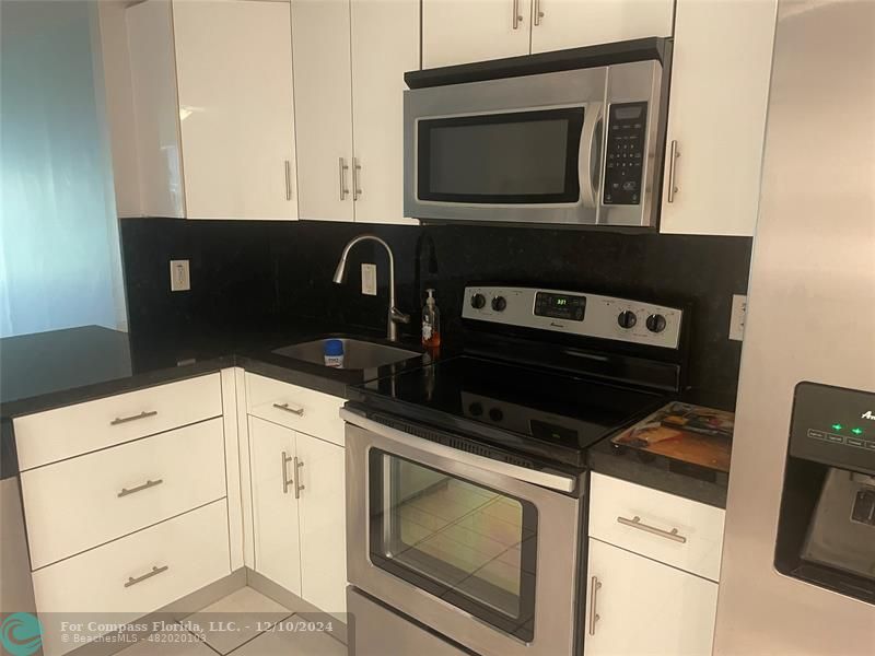 a kitchen with microwave cabinets and stove top oven