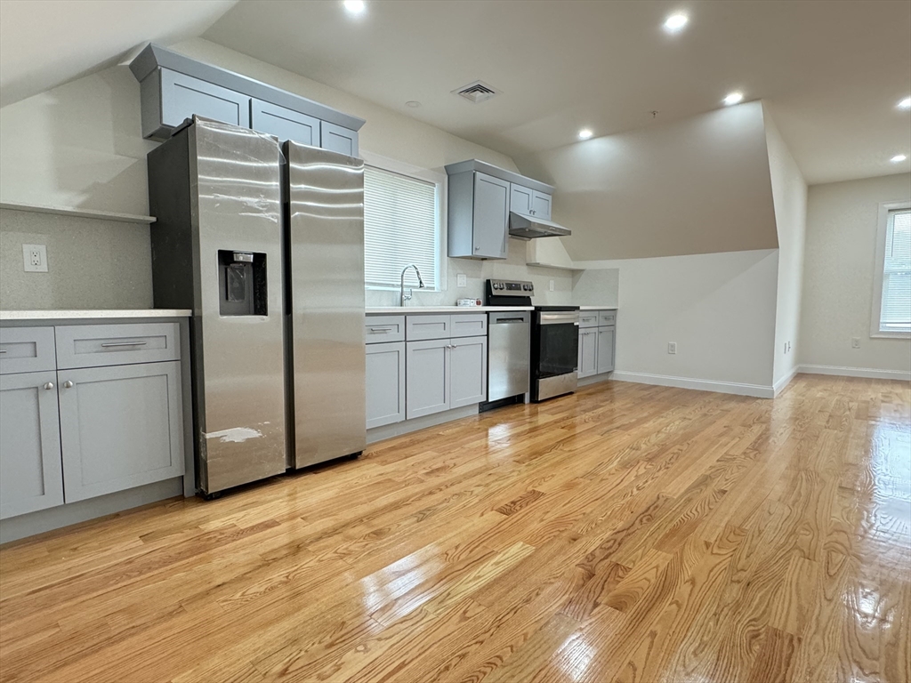 a kitchen with stainless steel appliances a refrigerator sink and cabinets