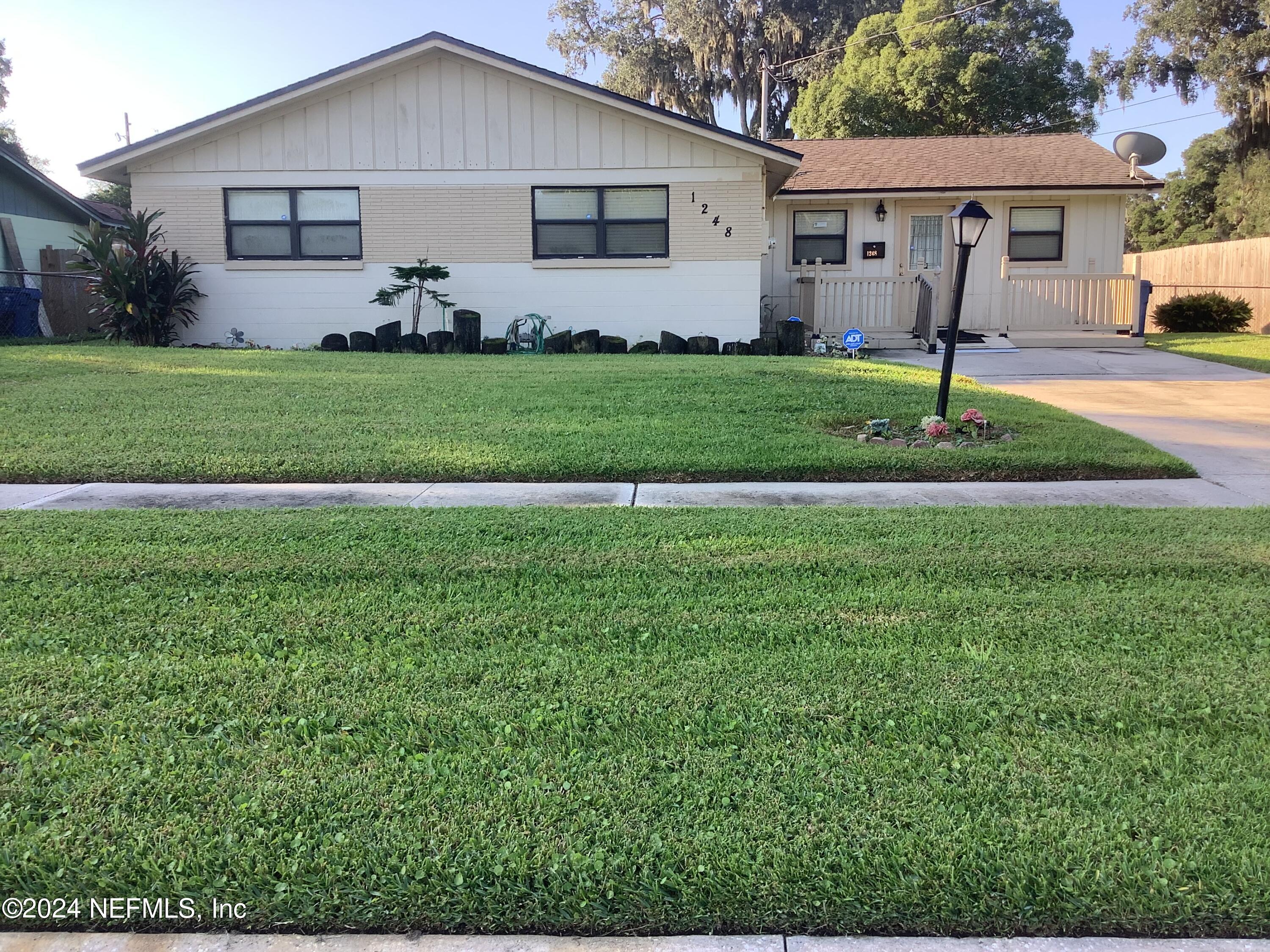 a front view of a house with a yard and trees