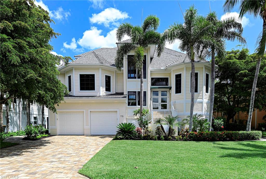 a front view of a house with a garden and trees