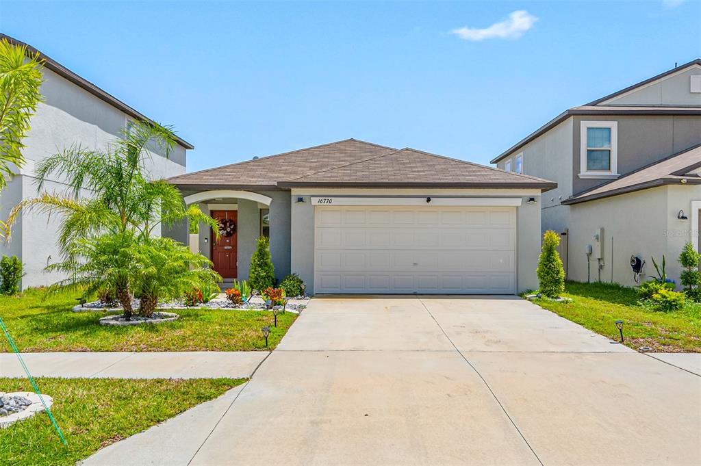 a front view of a house with a yard and garage