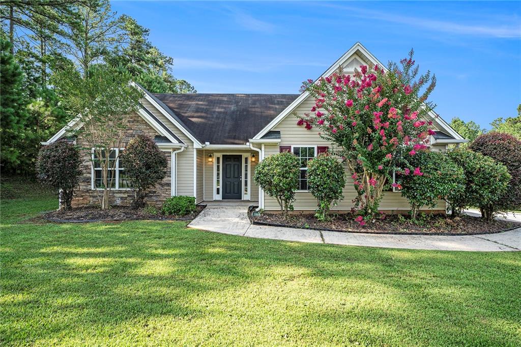 a view of a house with a yard and sitting area