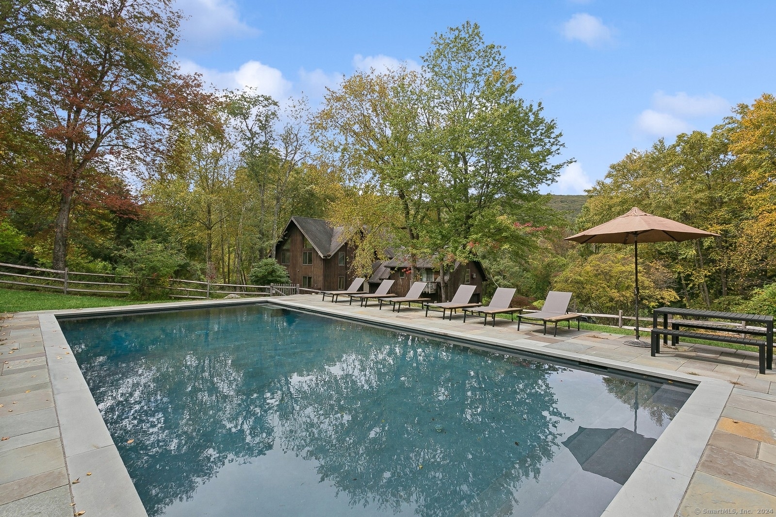 a view of a swimming pool with a table and chairs under an umbrella