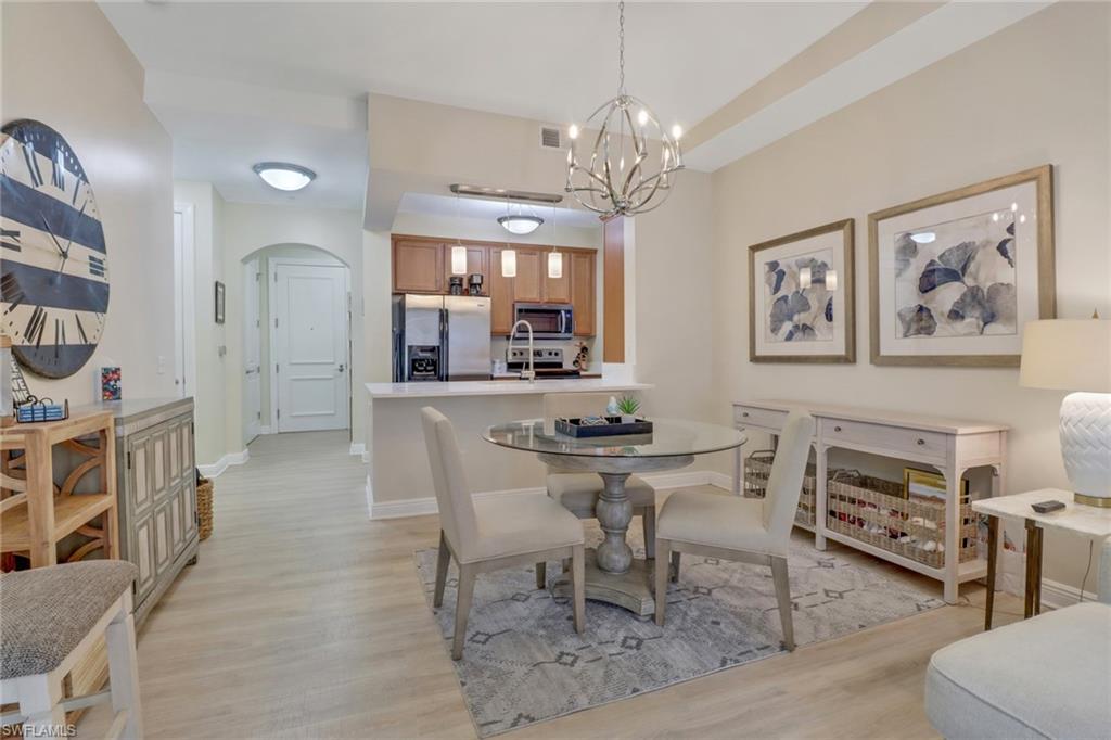 a view of a dining room with furniture a chandelier and wooden floor