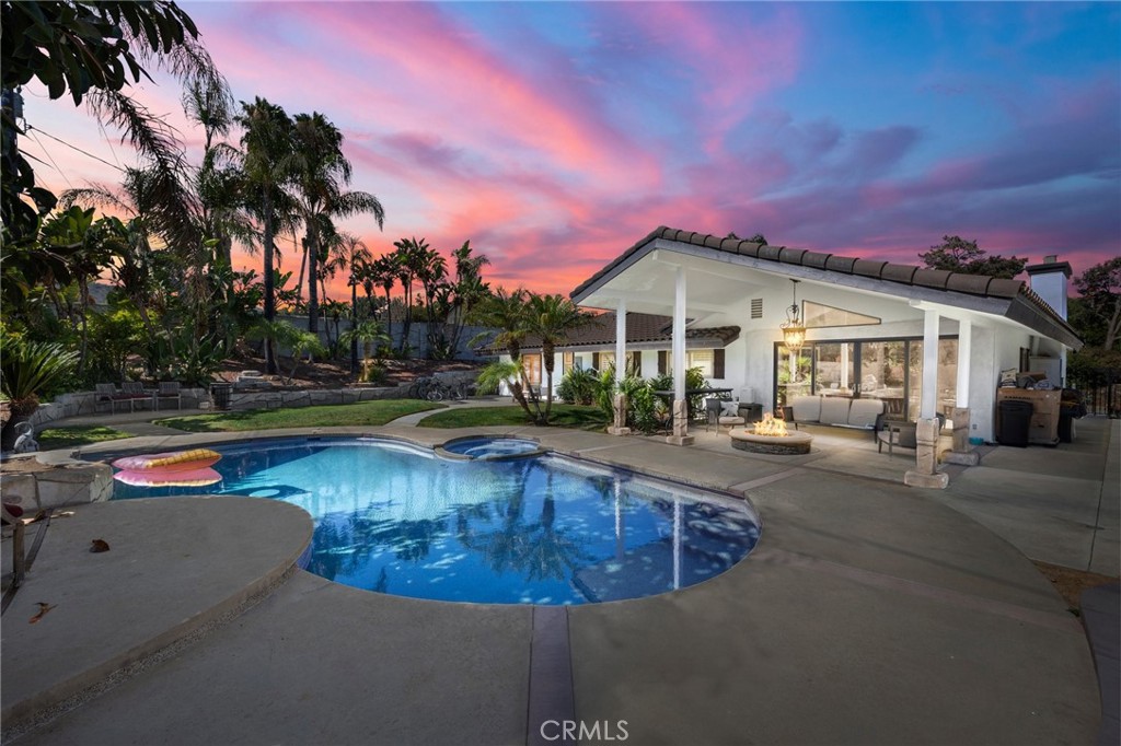 a view of a house with swimming pool and sitting area