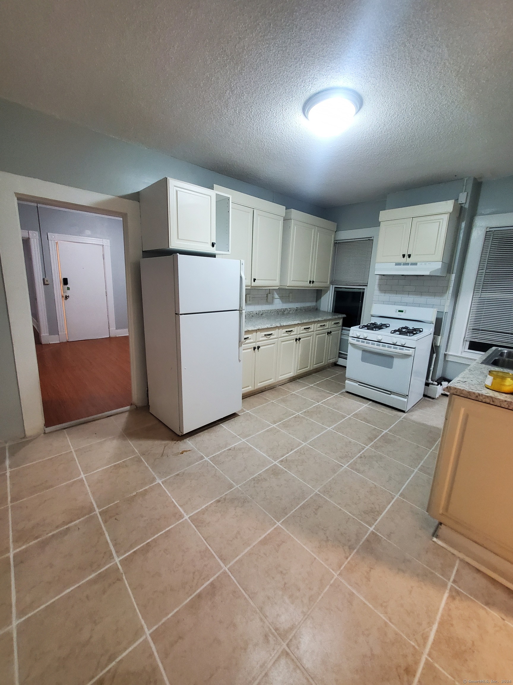 a kitchen with a refrigerator a stove top oven and a sink