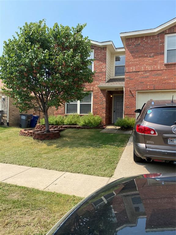 a car parked in front of a brick house next to a yard