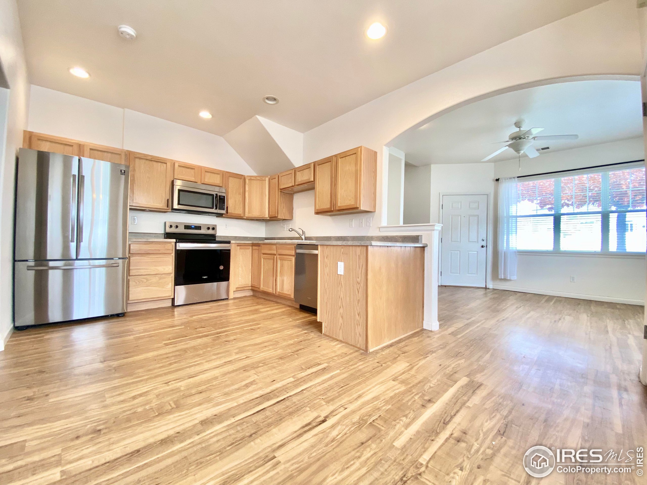 a kitchen with stainless steel appliances kitchen island granite countertop a stove and a refrigerator