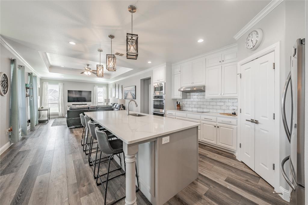 a kitchen with stainless steel appliances kitchen island a refrigerator and a stove top oven