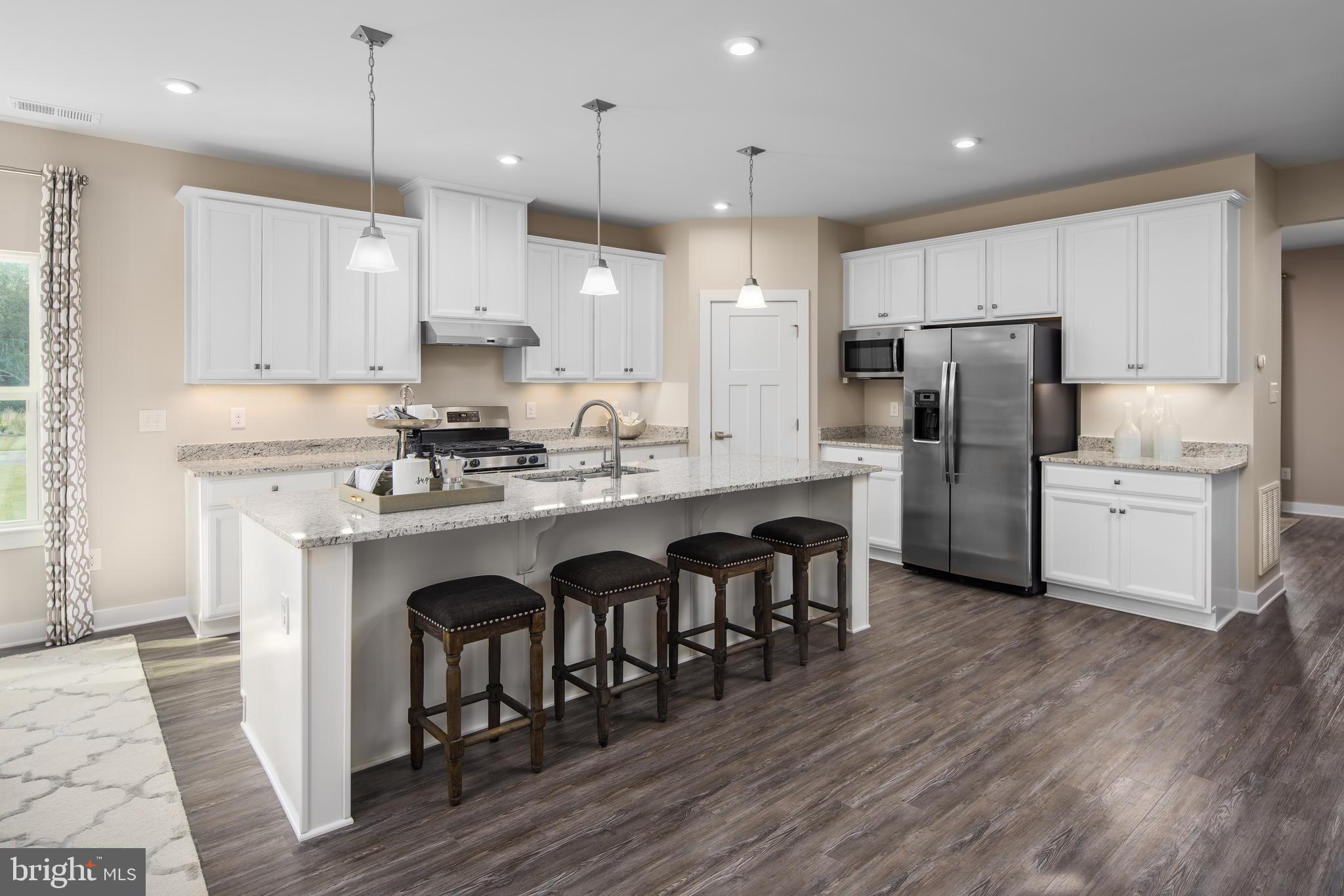 a kitchen with refrigerator cabinets and wooden floor