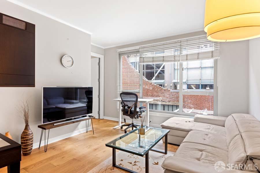 a living room with furniture a flat screen tv and a floor to ceiling window