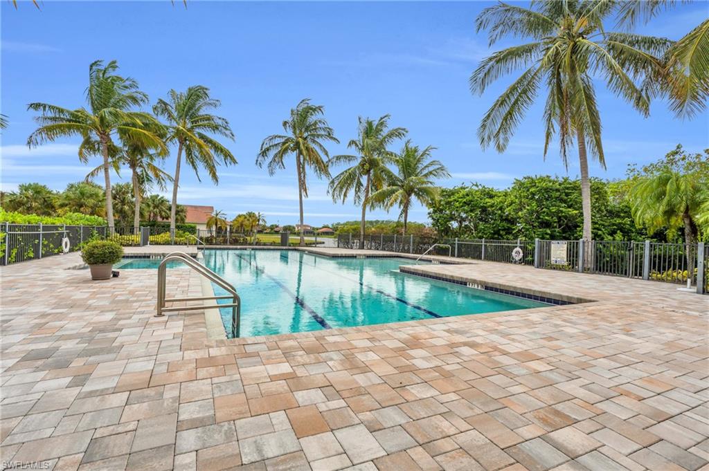 a view of swimming pool with a garden and palm trees