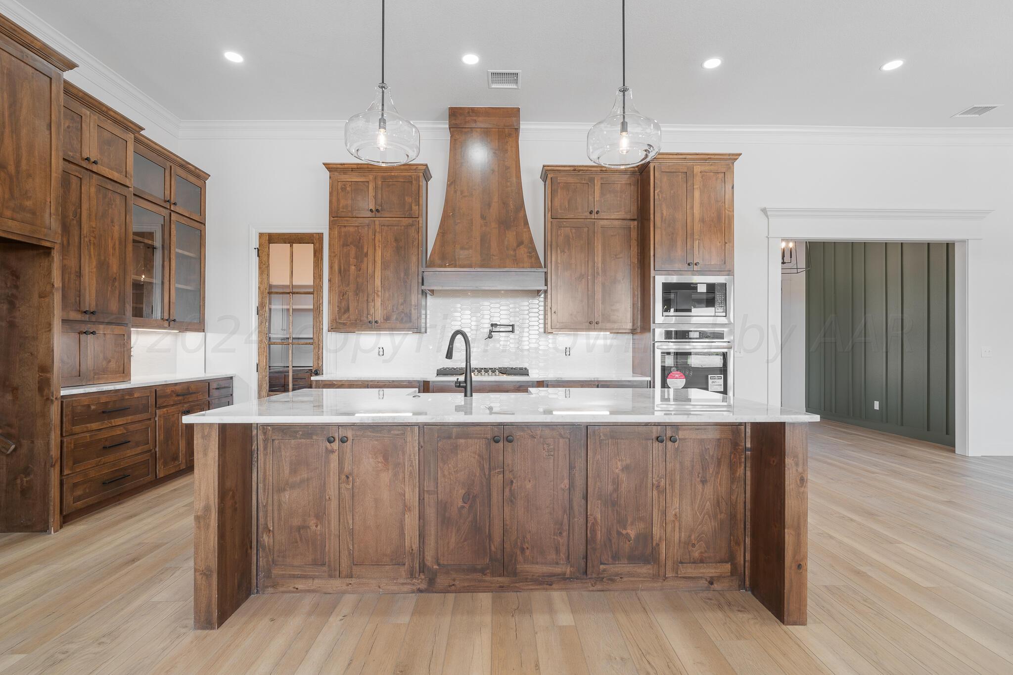 a large kitchen with stainless steel appliances kitchen island granite countertop a sink and cabinets