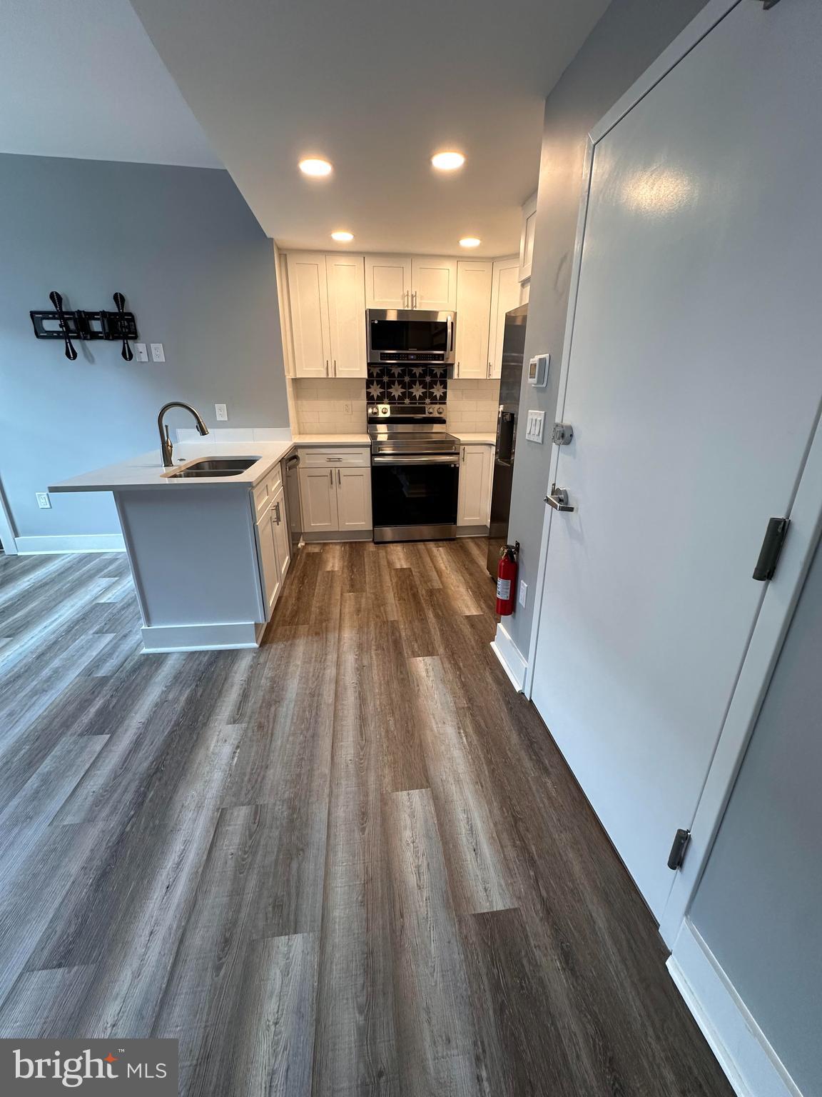 a view of kitchen with sink microwave and refrigerator