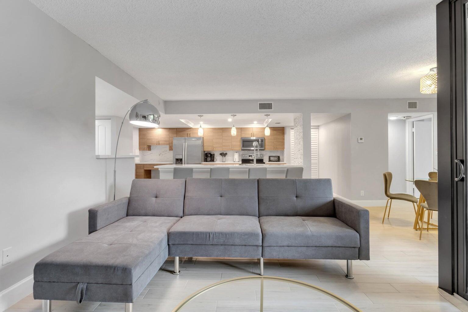 a living room with furniture and a view of kitchen