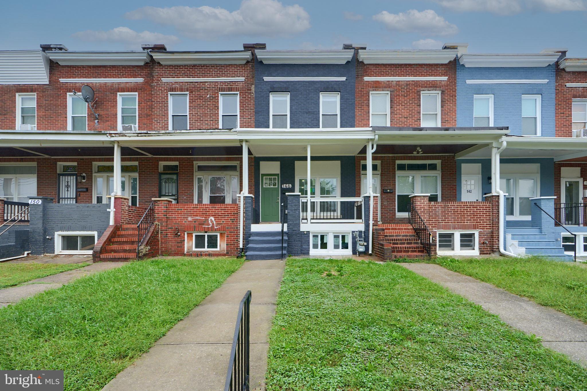 a front view of a brick building with a yard